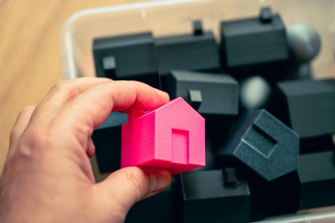 Man reviewing documents at a desk with a house model nearby.