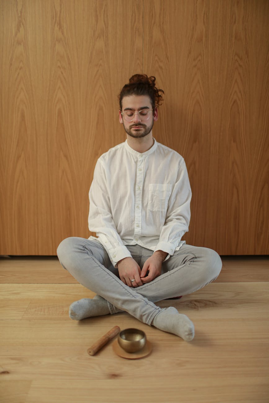 Woman meditating near a stack of coins and a small plant.